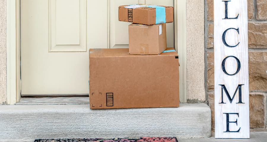 Boxes by the door of a residence with a welcome sign in Fort Worth